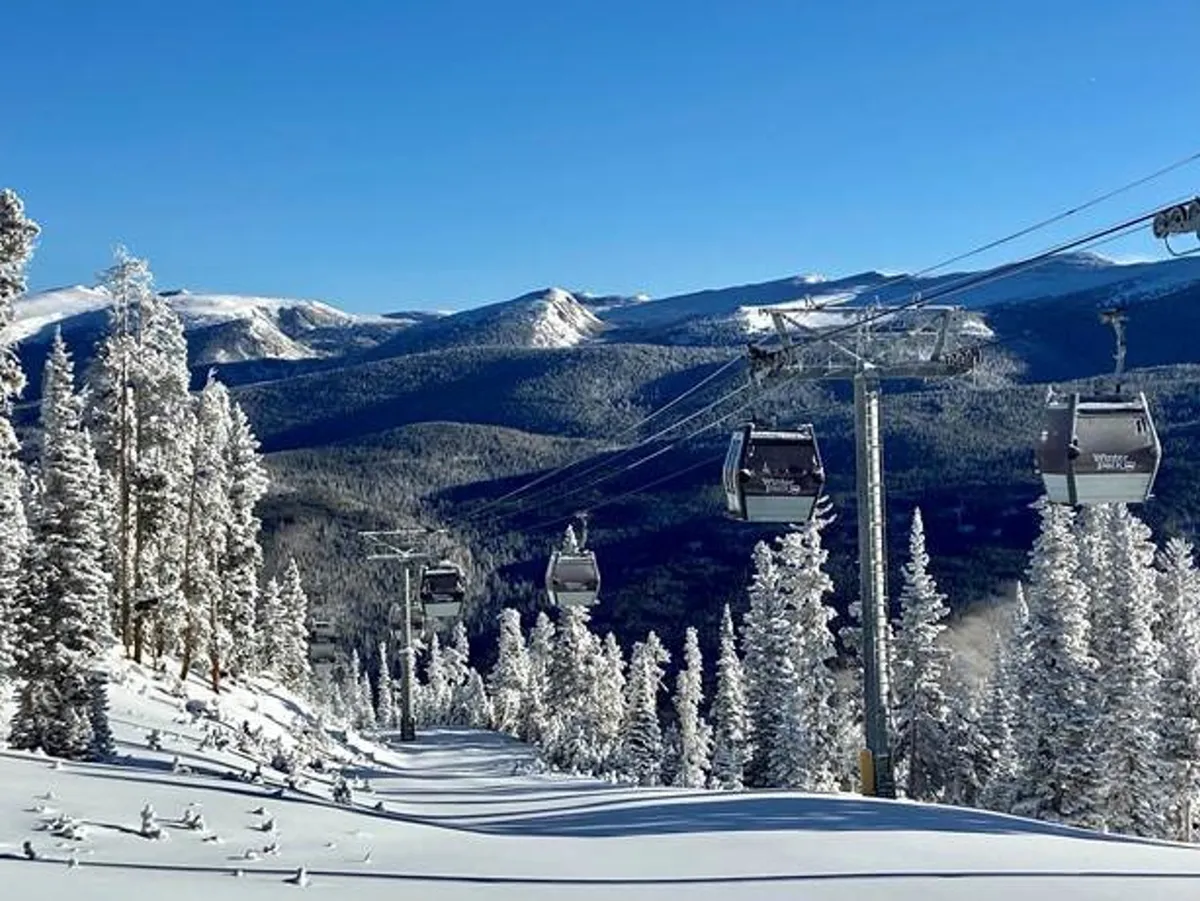 A panoramic exterior scene featuring ski lifts gliding above snow-covered trees, with a majestic mountain range in the background. The early morning light creates an invigorating atmosphere, emphasizing outdoor adventure and the region’s natural beauty.